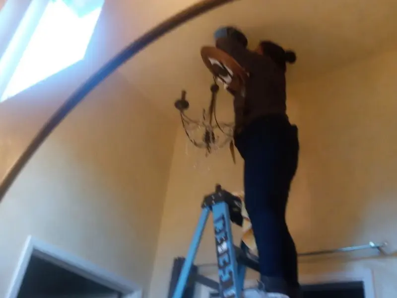 Electrician installing a chandelier in a Florence residence